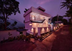 a large house is lit up at night at Nature Shade Pool Villa in Anachal