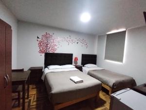 a bedroom with two beds and a wall with butterflies at MNk HOTEL in Arequipa