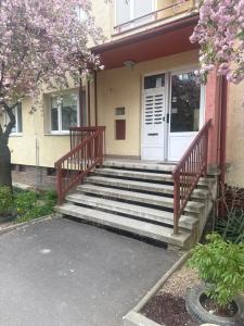 a house with stairs leading to a white door at Apartment Centrum in Lučenec