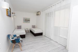 a white room with two beds and a chair at Apartment DESi in Balchik