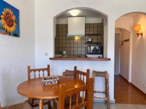 a dining room with a table and a kitchen at Basic Comfort Studio Poblat tipic 0167 in Empuriabrava +21 photos