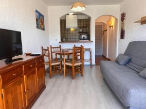 a living room with a couch and a table with chairs at Basic Comfort Studio Poblat tipic 0167 in Empuriabrava