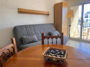 a living room with a couch and a table at Basic Comfort Studio Poblat tipic 0167 in Empuriabrava