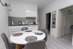 a kitchen and dining room with a white table and chairs at Apartment DESi in Balchik