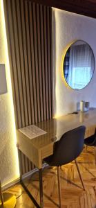 a wooden desk with a chair and a mirror at House Dado in Jezerce