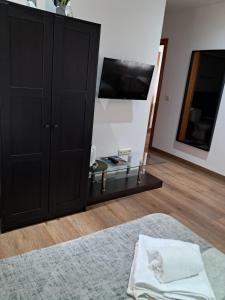 a bedroom with a black cabinet and a mirror at La orilla del sella in Cangas de Onís