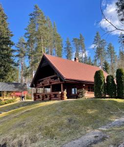 a log cabin with a large yard in front of it at Oksa Puhkemaja in Võru