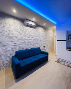 a blue couch in a living room with a brick wall at REGINA ANNA HOME in Bari