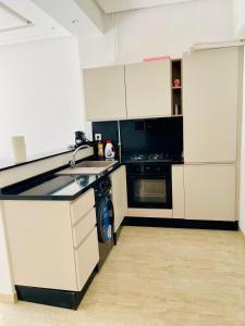a kitchen with white cabinets and a dishwasher at Apparemment s1 vu sur mer et piscine in Zarzis