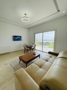 a living room with a couch and a table at Apparemment s1 vu sur mer et piscine in Zarzis