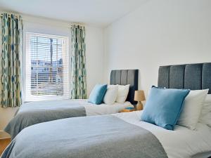 two beds in a room with a window at Finest Retreats - Centre View in Sidmouth