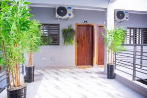 a room with three potted plants in front of a door at SARALIS Home in Abidjan