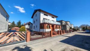 a house with a fence in front of it at Willa 2 piętro in Szczecinek