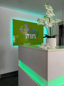 a counter with a vase with white flowers on it at Hotel City Inn in Magdeburg