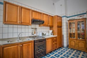 La cuisine est équipée de placards en bois et d'un four avec plaques de cuisson. dans l'établissement Vila Sinaia by Olala Homes, à Sinaia