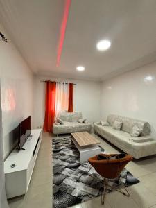 a living room with two couches and a television at Daryl House Liberte 2 in Dakar