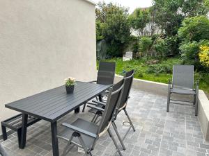 a black table and chairs on a patio at Dream House Paris 5 chambres proche M7et M14 in Villejuif