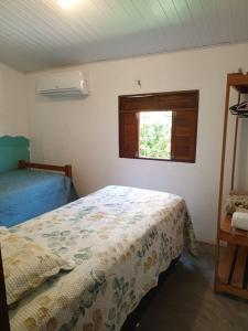 a bedroom with a bed and a window at Casa Flora Canoa Quebrada in Canoa Quebrada