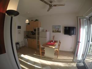 a kitchen and dining room with a table and a refrigerator at Studios Lav in Privlaka