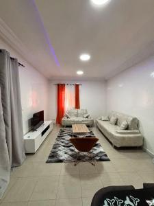 a living room with two couches and a tv at Daryl House Liberte 2 in Dakar