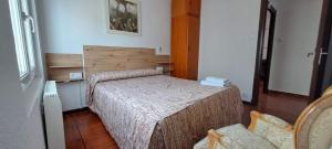 a small bedroom with two beds and a chair at APARTAMENTO SUJARRERA in Villacarriedo