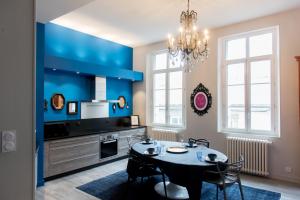 a kitchen with a table and a blue wall at Le Blue Note intra-muros - Bel appartement de standing in Saint Malo