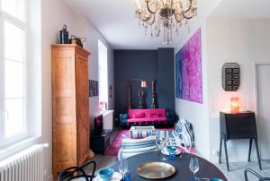 a dining room with a table and chairs and a chandelier at Le Blue Note intra-muros - Bel appartement de standing in Saint Malo +16 photos