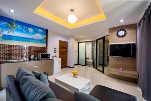 a living room with a couch and a tv at The Lucky Beach Ao Nang in Ao Nang Beach +31 photos