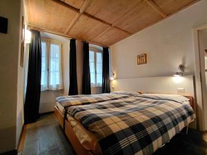 a bedroom with a bed in a room with windows at B&B Ploncher in Chiavenna