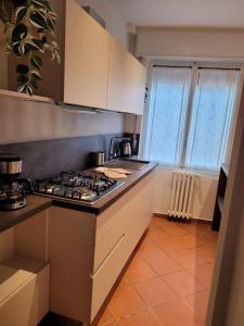 a kitchen with a stove top oven next to a window at Ca' Irene in Stresa