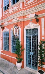 ein orangefarbenes Gebäude mit zwei Topfbäumen davor in der Unterkunft Bed & breakfast Villa Carmo in Salvador