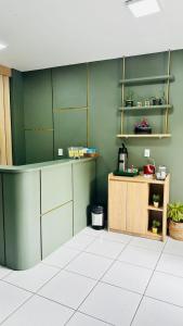 a kitchen with green walls and a wooden counter at Hotel Shalom in Juazeiro do Norte