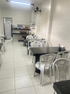 a dining room with tables and white chairs and a refrigerator at Hotel Shalom in Juazeiro do Norte +26 photos