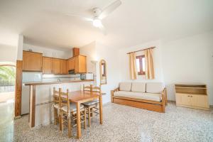 a kitchen and dining room with a table and a couch at Morans-C in Es Pujols +6 photos