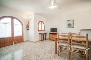a dining room with a table and a television at Morans-C in Es Pujols