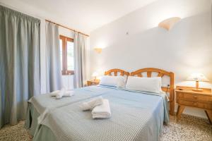 a bedroom with two beds with towels on them at Morans-C in Es Pujols