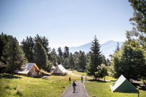 a group of people walking down a road with tents at Huttopia Font Romeu in Font-Romeu