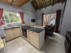 a kitchen with a sink and a stove top oven at Frangipani guesthouse in Hartbeespoort +4 photos