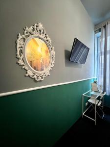 a mirror on a wall with a chair and a table at Royal Aparthotel Piotrkowska 116 in Łódź