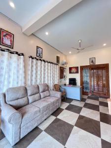 a living room with a couch and a checkered floor at VV Guest House & Rooms in Tiruvannāmalai
