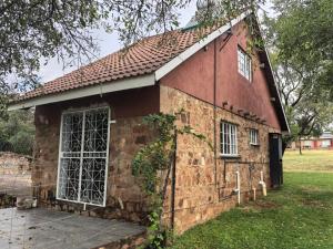 an old red brick building with a large window at Frangipani guesthouse in Hartbeespoort