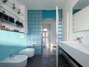 a bathroom with a white toilet and a sink at Design Ferienhaus Kamerun an der Elbe in Damnatz