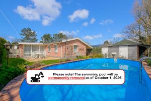 a house with a swimming pool in front of it at Vakantiehuis Springtij met privé zwembad - Julianadorp aan Zee in Julianadorp
