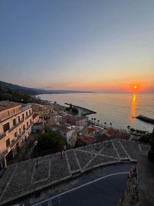 Blick auf eine Stadt bei Sonnenuntergang über dem Wasser in der Unterkunft Ondablurooms2 in Pizzo