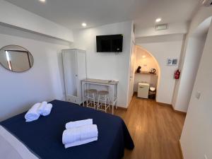 ein Schlafzimmer mit einem blauen Bett, auf dem Handtücher liegen in der Unterkunft Ondablurooms2 in Pizzo