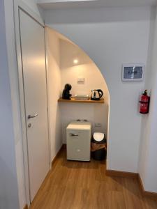 Ein Flur mit einem Torbogen, der zu einem kleinen Kühlschrank führt in der Unterkunft Ondablurooms2 in Pizzo