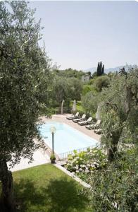a swimming pool with lounge chairs in a yard at appartamenti ceccherini debora luna in Malcesine