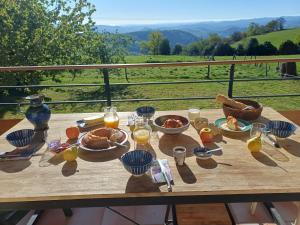 a wooden table with food and glasses of orange juice at La Chambre du Bout du Monde in Bouillac