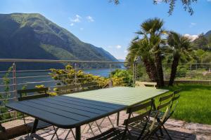 a picnic table with a view of the water and mountains at Il Tentione in Valsolda