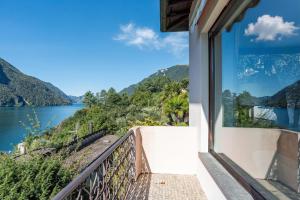 a balcony with a view of a lake and mountains at Il Tentione in Valsolda